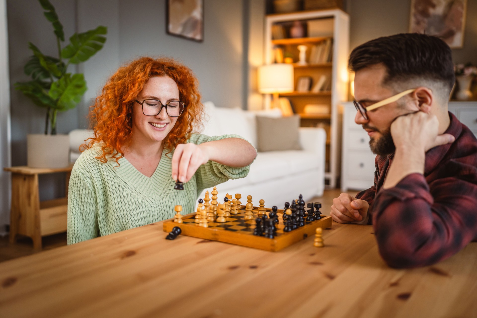 young couple in love enjoy and spend time together at home play chess